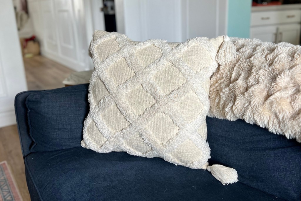 linen tufted throw pillow on navy couch