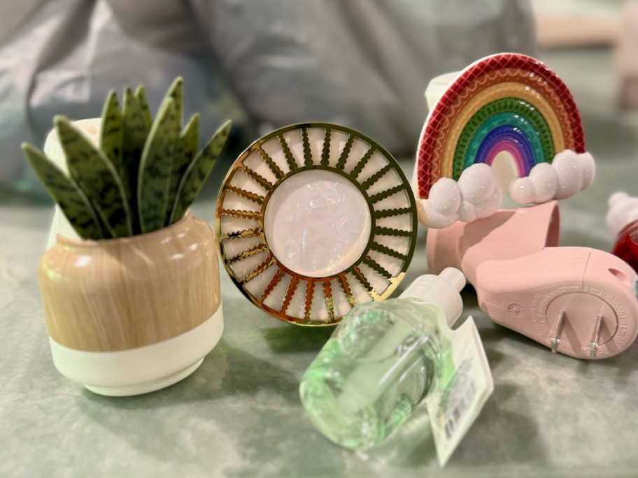 3 fragrance plug-ins shaped like a succulent, a sunburst, and a rainbow