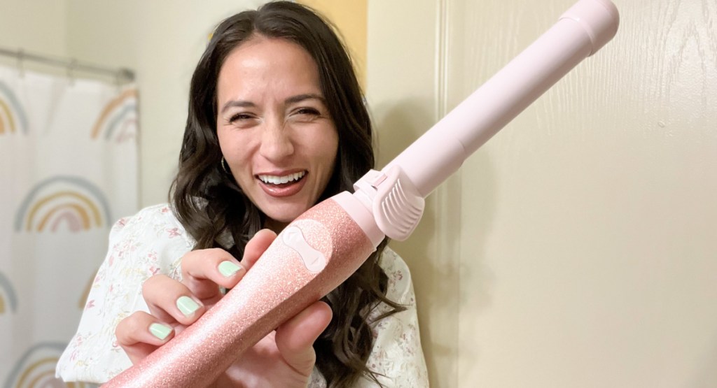 woman holding pink glitter beach waver