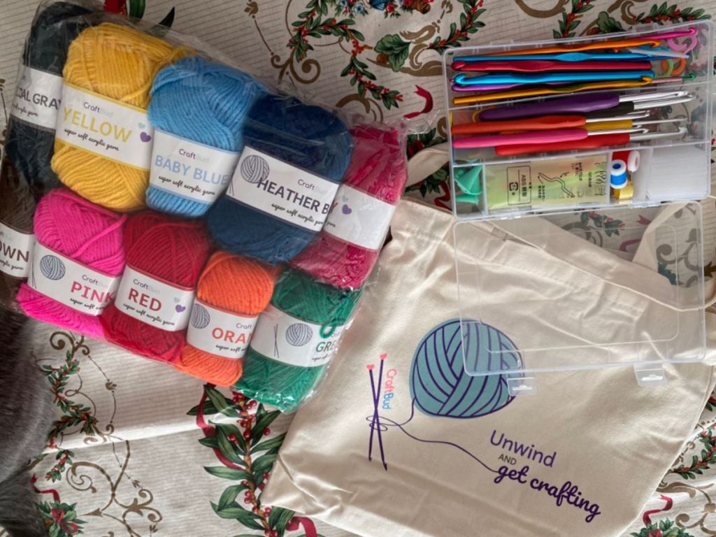 A craftbud Crochet Kit on a bed