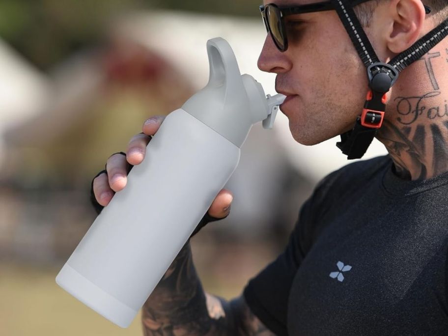 A man drinking out of a stainless water bottle 