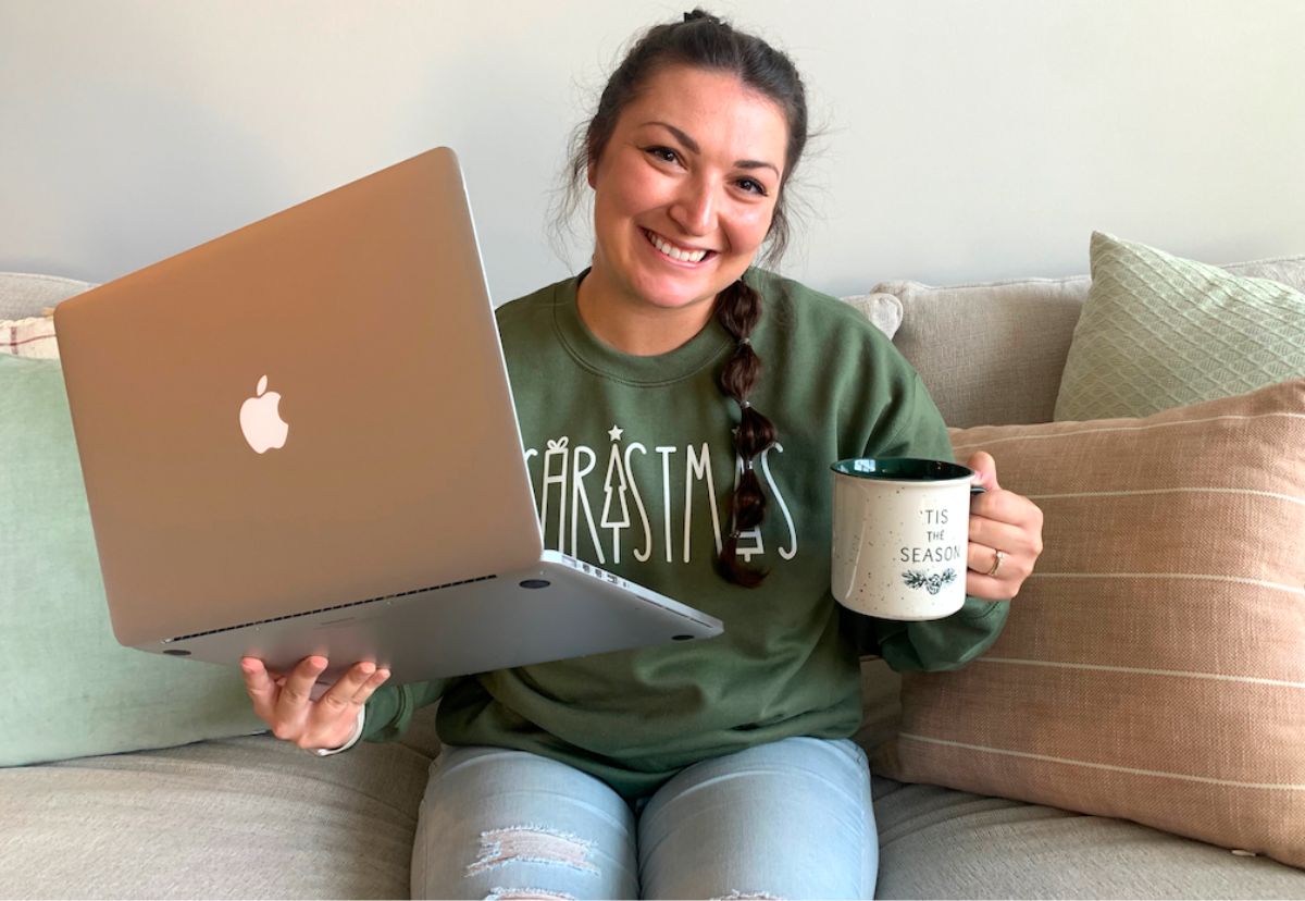 woman with a mac book and a mug of coffee ready to go online Holiday shopping