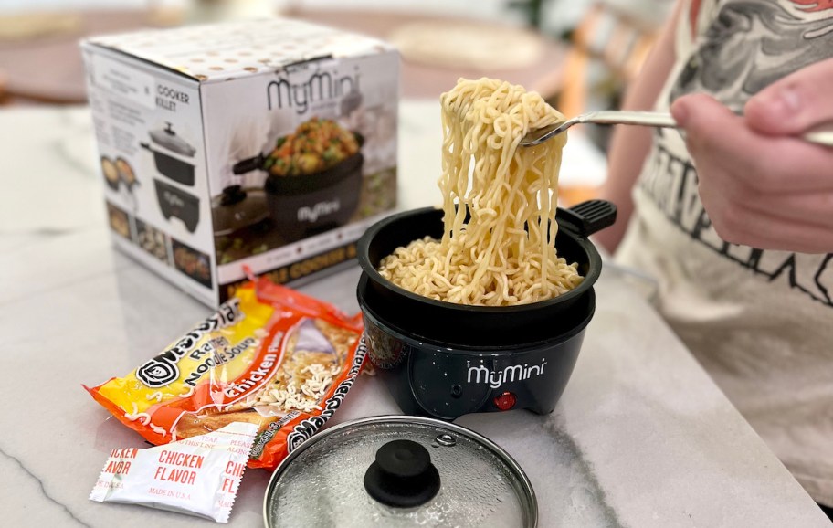 guy scooping ramen noodles out of mymini noodle cooker