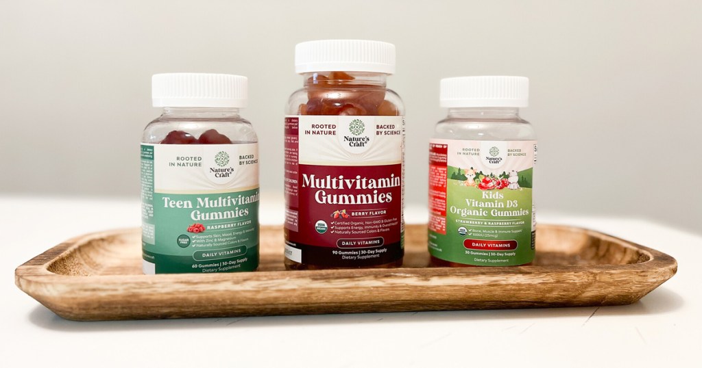 three bottles of Nature's Craft Vitamin Gummies on wood tray