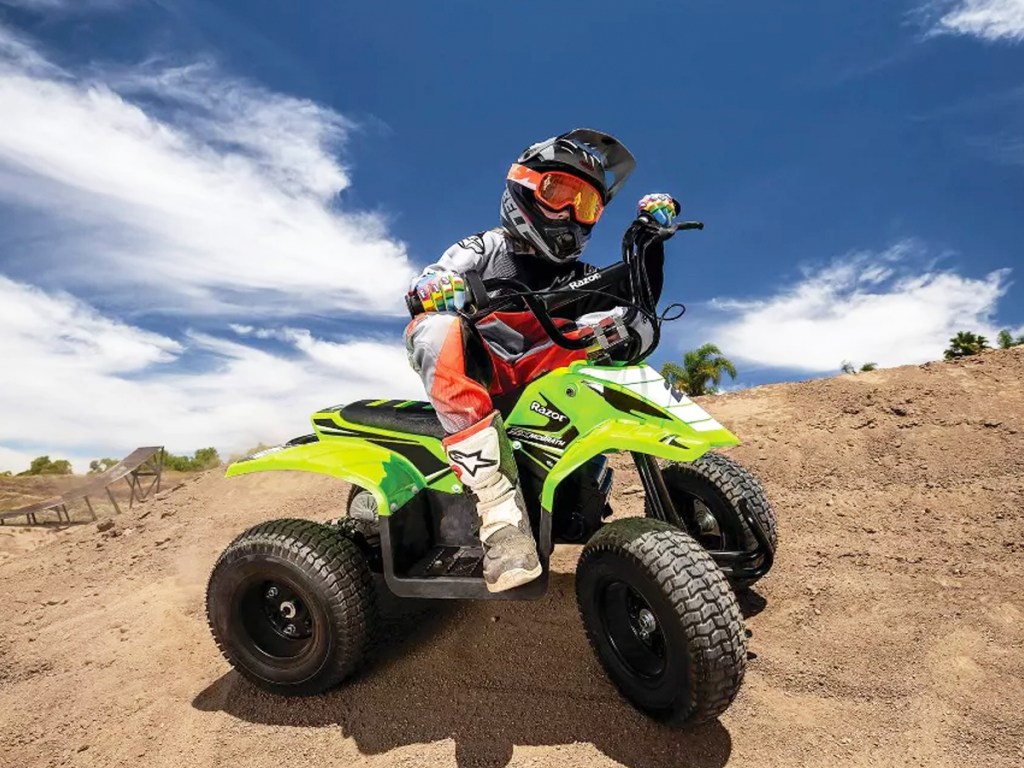 boy riding a green razor brand quad