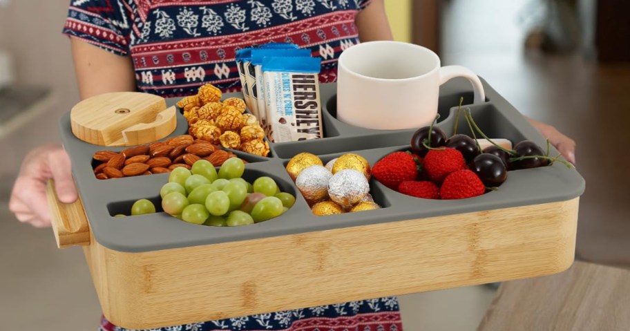 woman carrying a couch caddy tray full of food