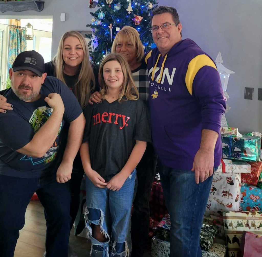 family standing in front of christmas tree