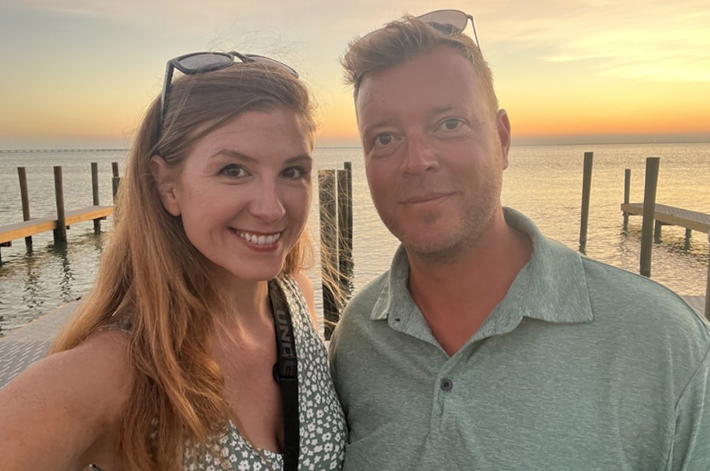 Selfie of woman and man standing at dock by water