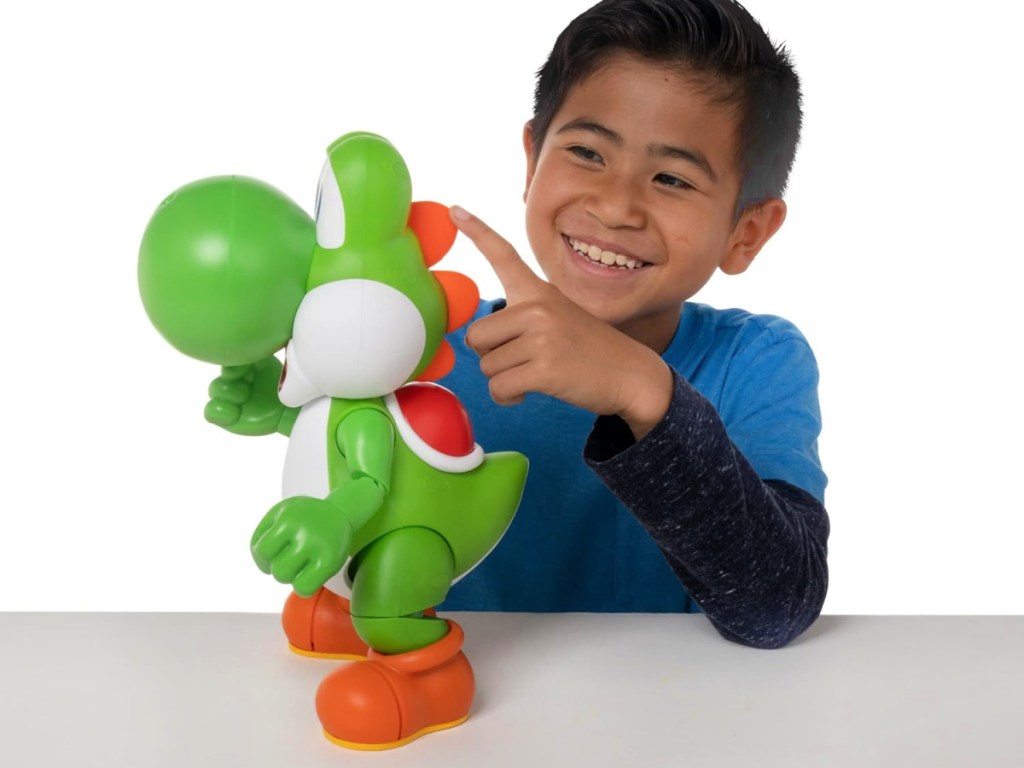 boy pointing at a nintendo yoshi toy