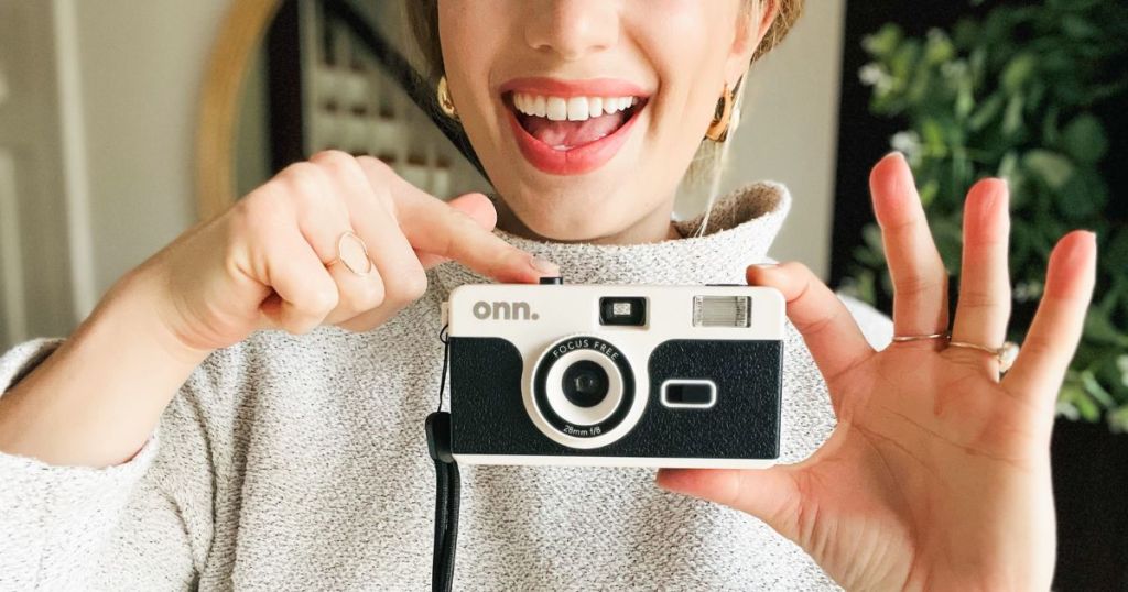 A woman holding a onn. Reusable 35mm Camera with Flash