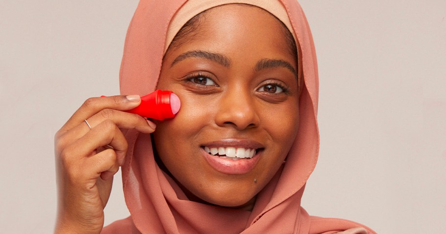 woman using skin reviving roller on face