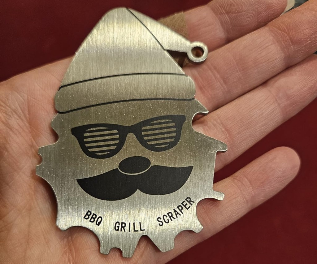 holding a santa-shaped BBQ Grill scraper