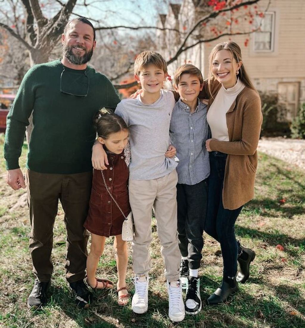 family standing outside in grass wearing fall clothes