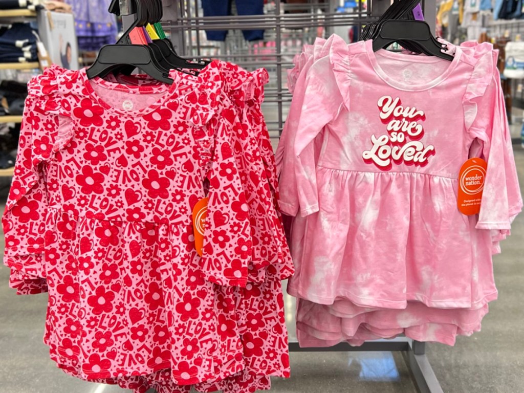 two pink toddler valentines dresses hanging in walmart store