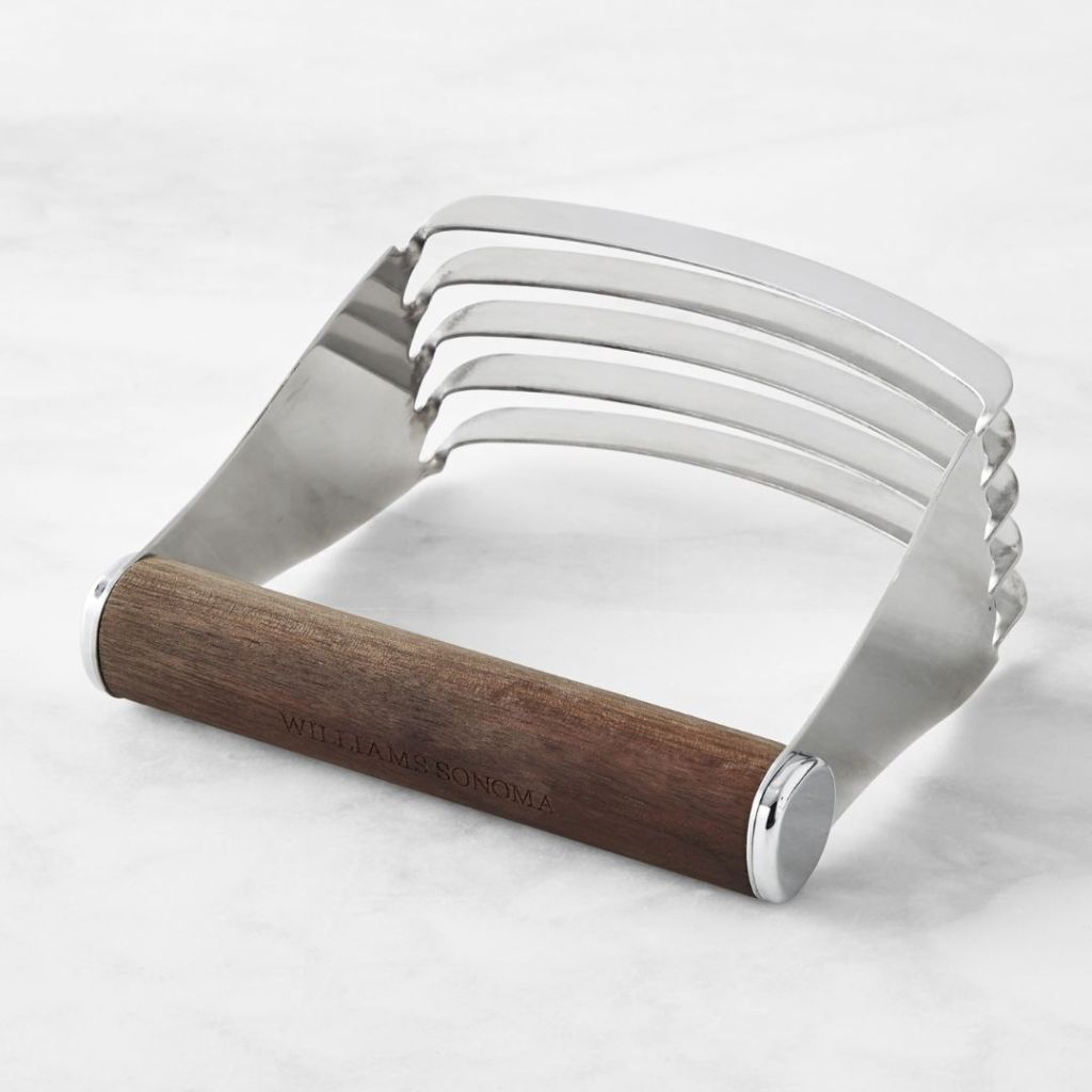 steel pastry cutter with wooden handle laying on counter