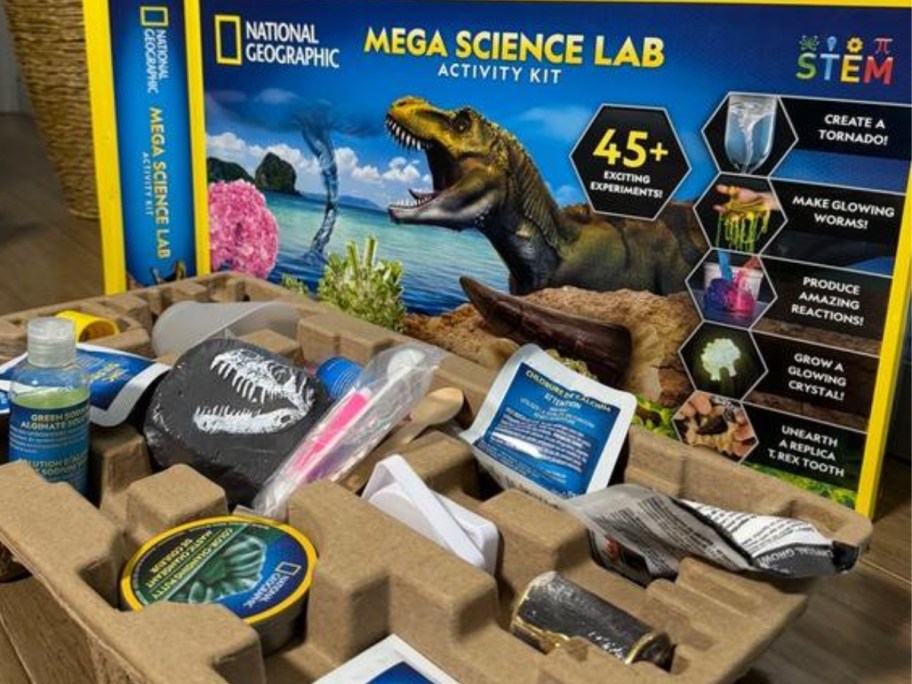 a National Geographic Mega Science Lab Kit box with a dinosaur on it, the contents of the box in front of it