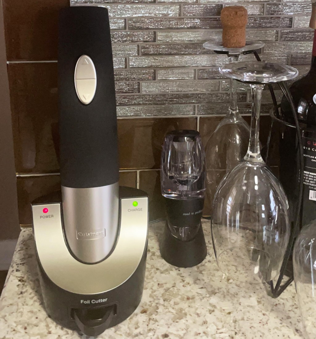 black cordless wine bottle opener on kitchen counter near wine glasses