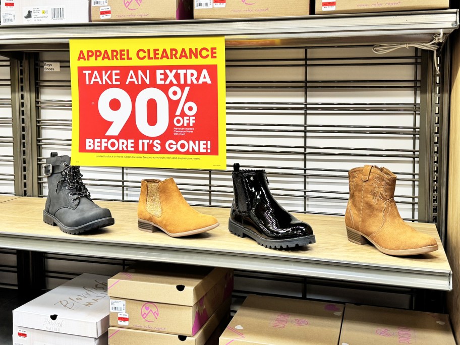 girls boots on store display with yellow and red clearance sign