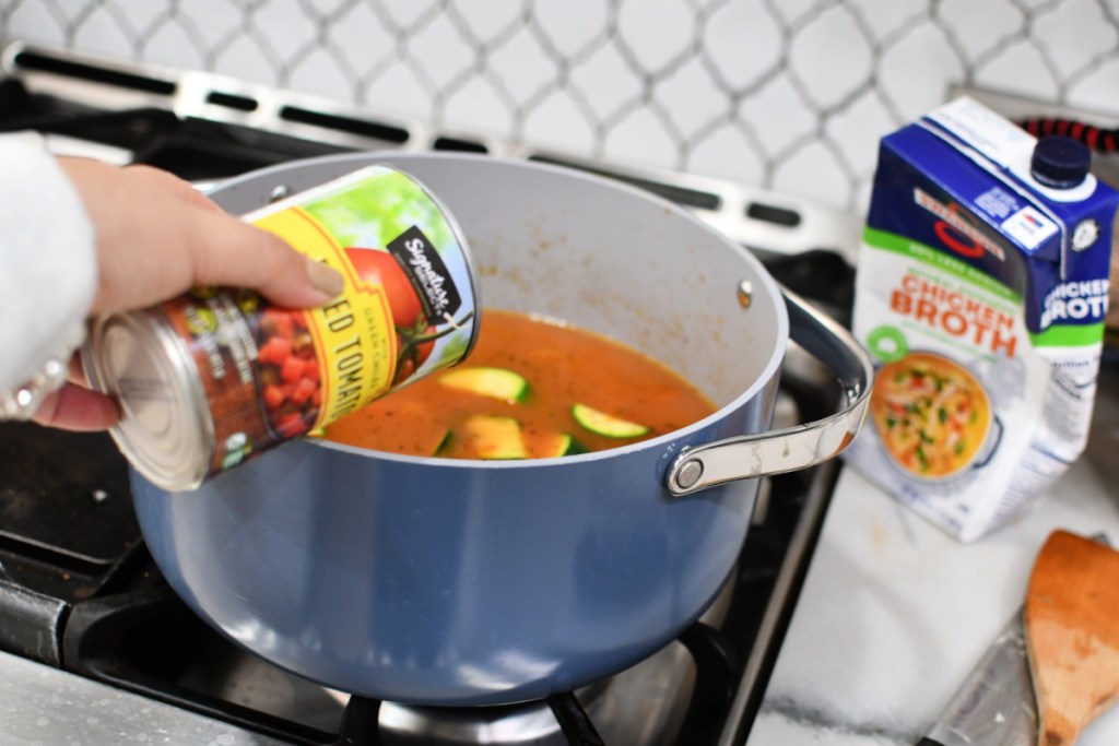 adding diced tomatoes to soup