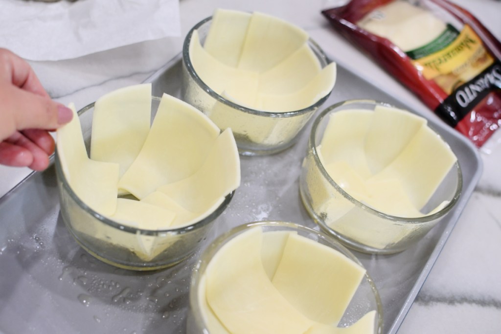 adding sliced cheese to a bowl