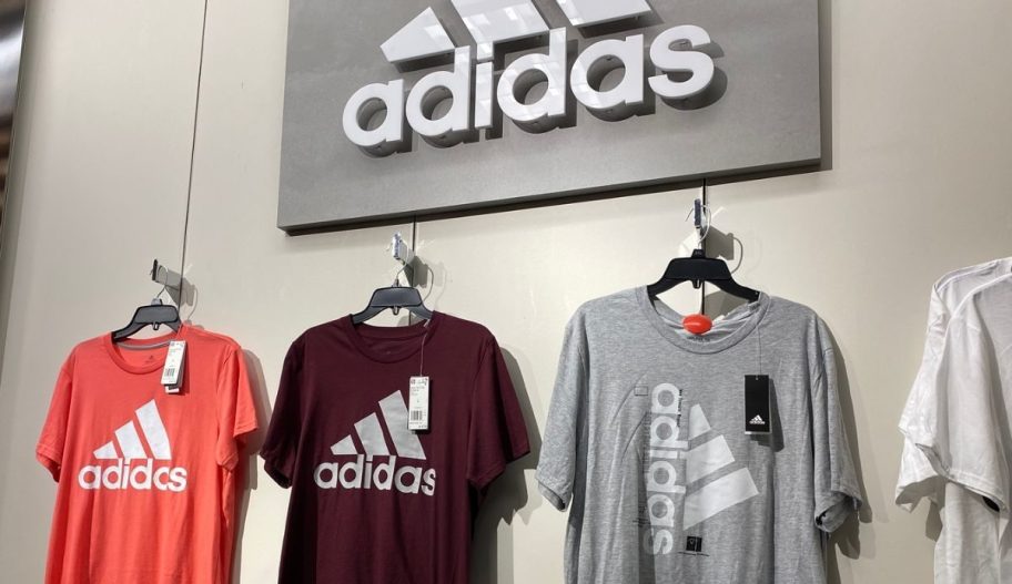 3 adidas t-shirts on a wall display in a store