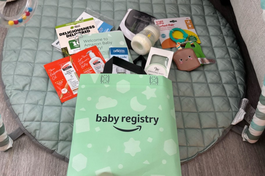 green baby registry bag with baby items coming out