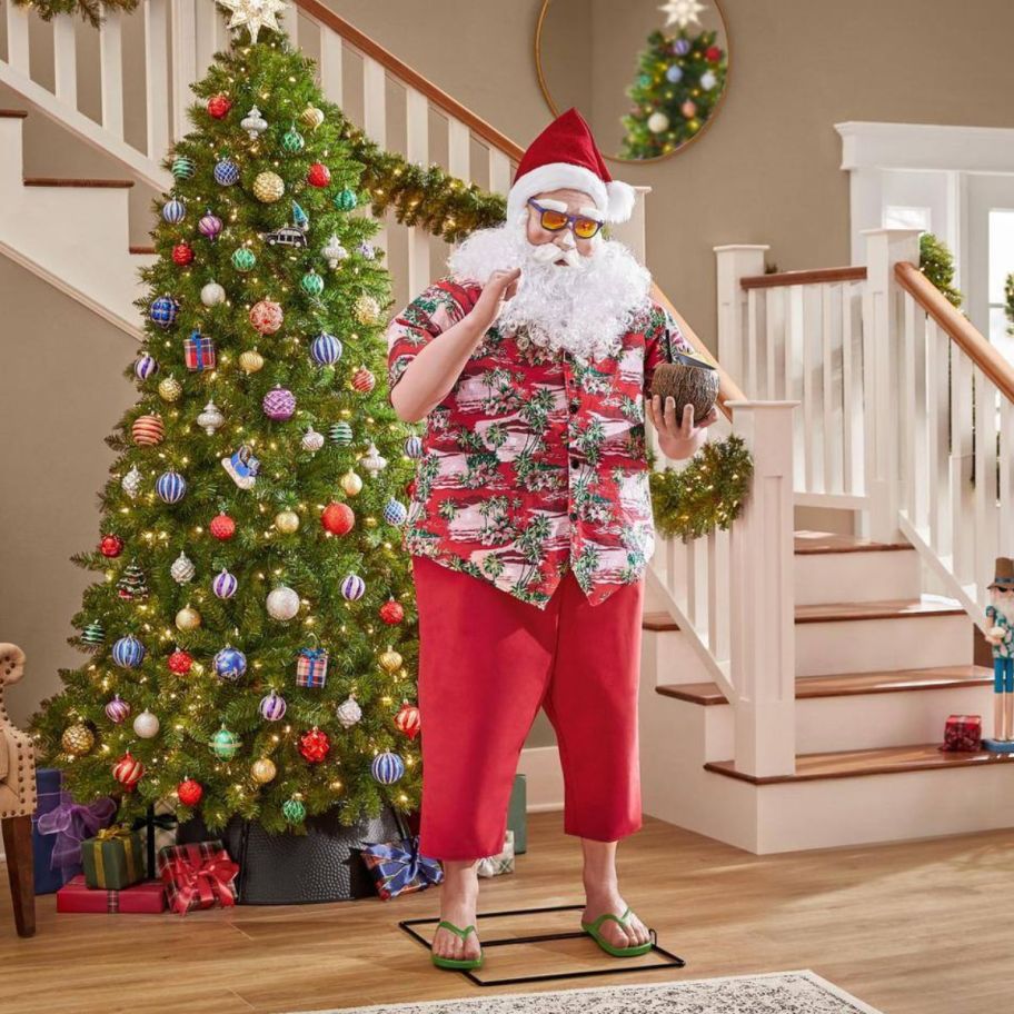 animatronic beach santa next to a decorated christmas tree