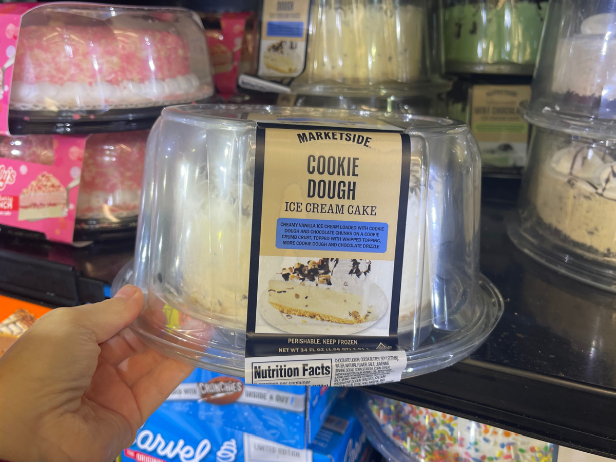 hand holding a market side cookie dough ice cream cake inside of a Walmart freezer