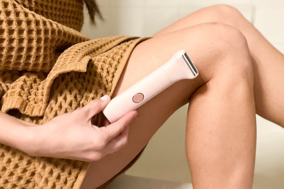 holding electric razor against leg