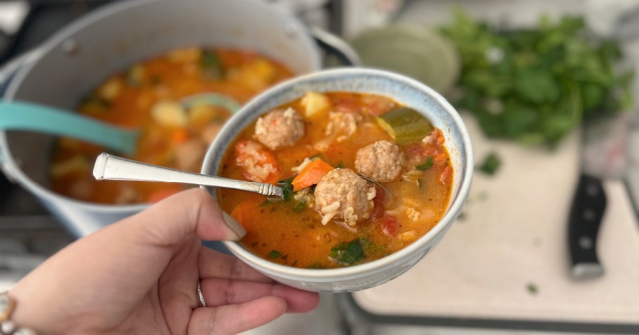 holding a bowl of mexican meatball albondigas soup