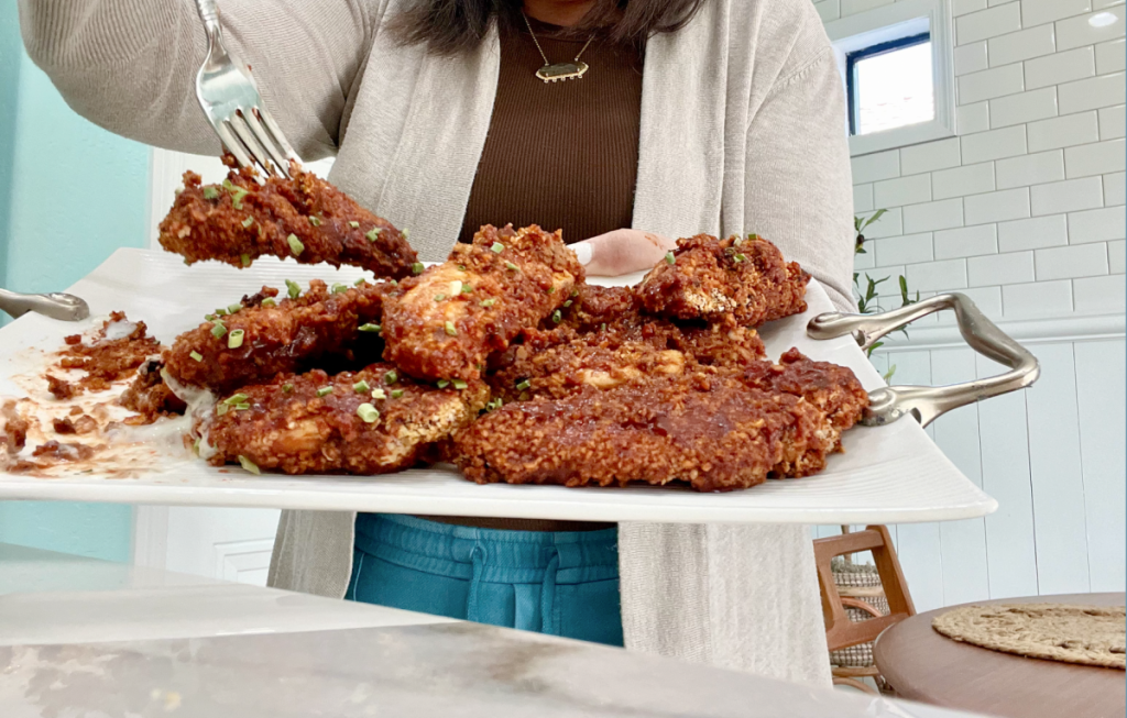 holding a tray of honey sriracha chicken tenders