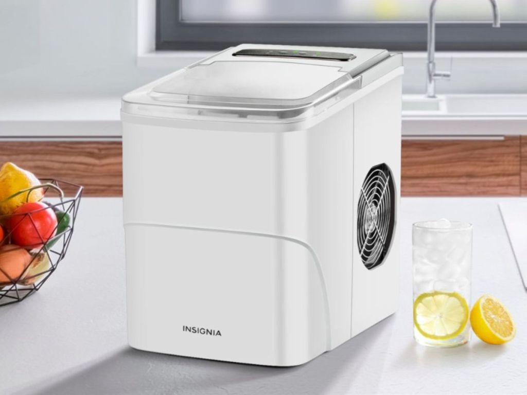 insiginia ice maker sitting on counter next to glass