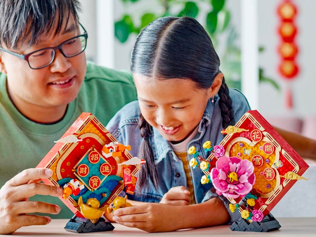 man and child playing with lego new year set