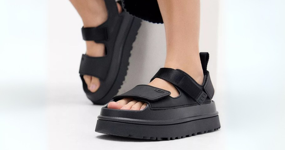 women's feet wearing black chunky UGG sandals