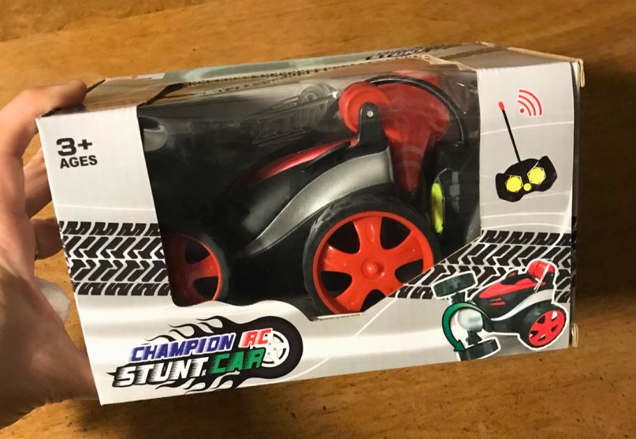 small red and black remote control stunt car with safety cones and remote control in box