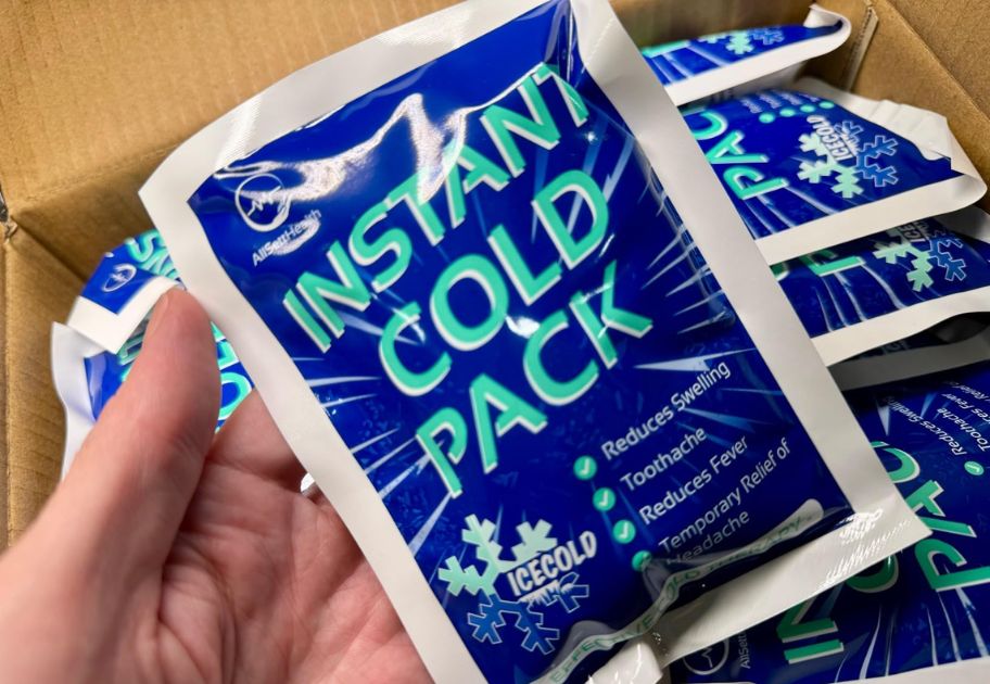 hand holding an Instant Cold Pack with a box of more behind her