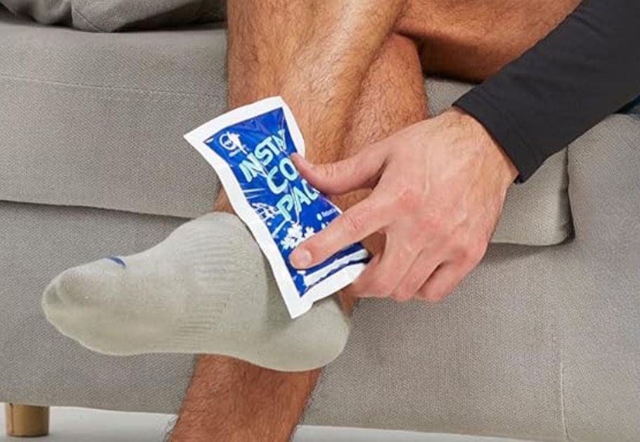 man holding an Instant Cold pack on an injured ankle