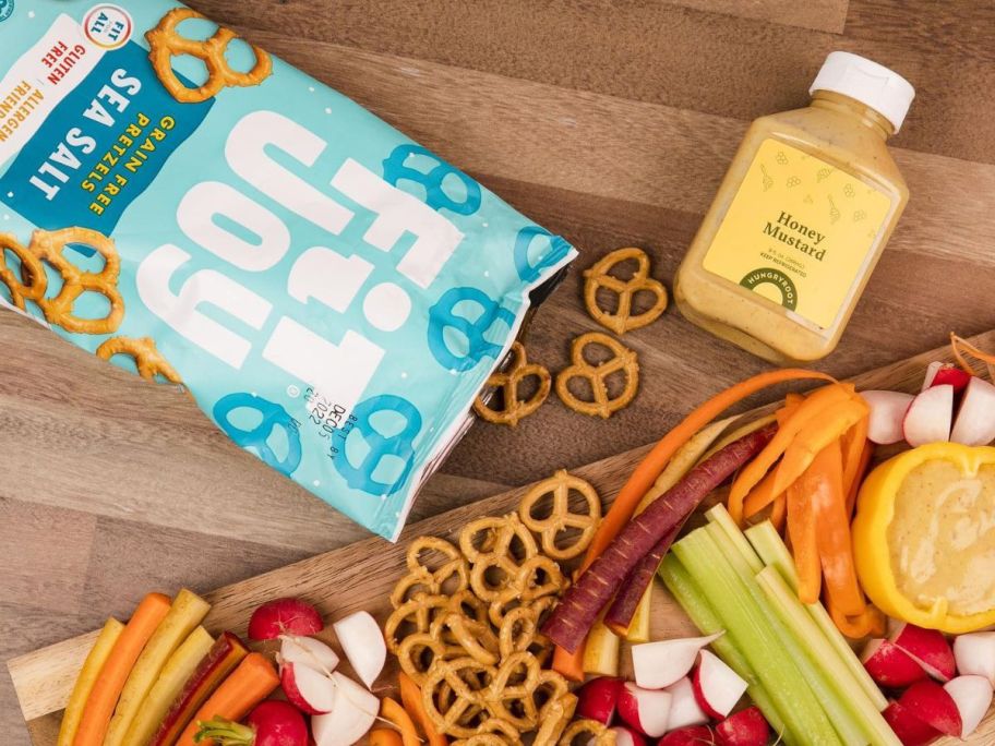 A Bag of Fit Joy Sea Salt Pretzel Twists next to a charcutterie board