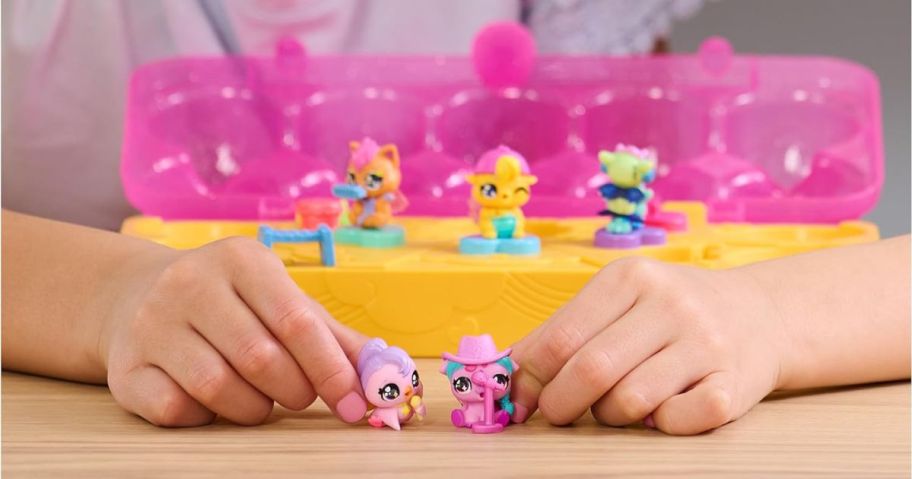 Child's hands playing with a Hatchimals carton