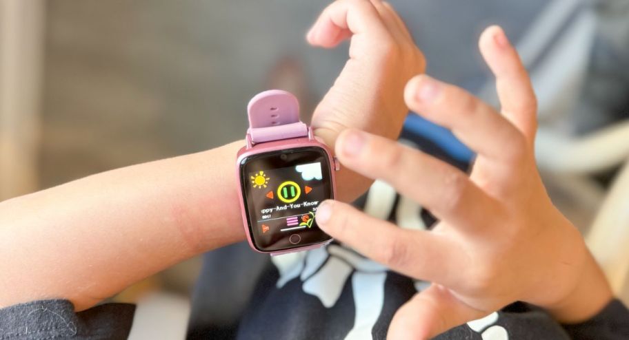 Kid playing with smartwatch in pink