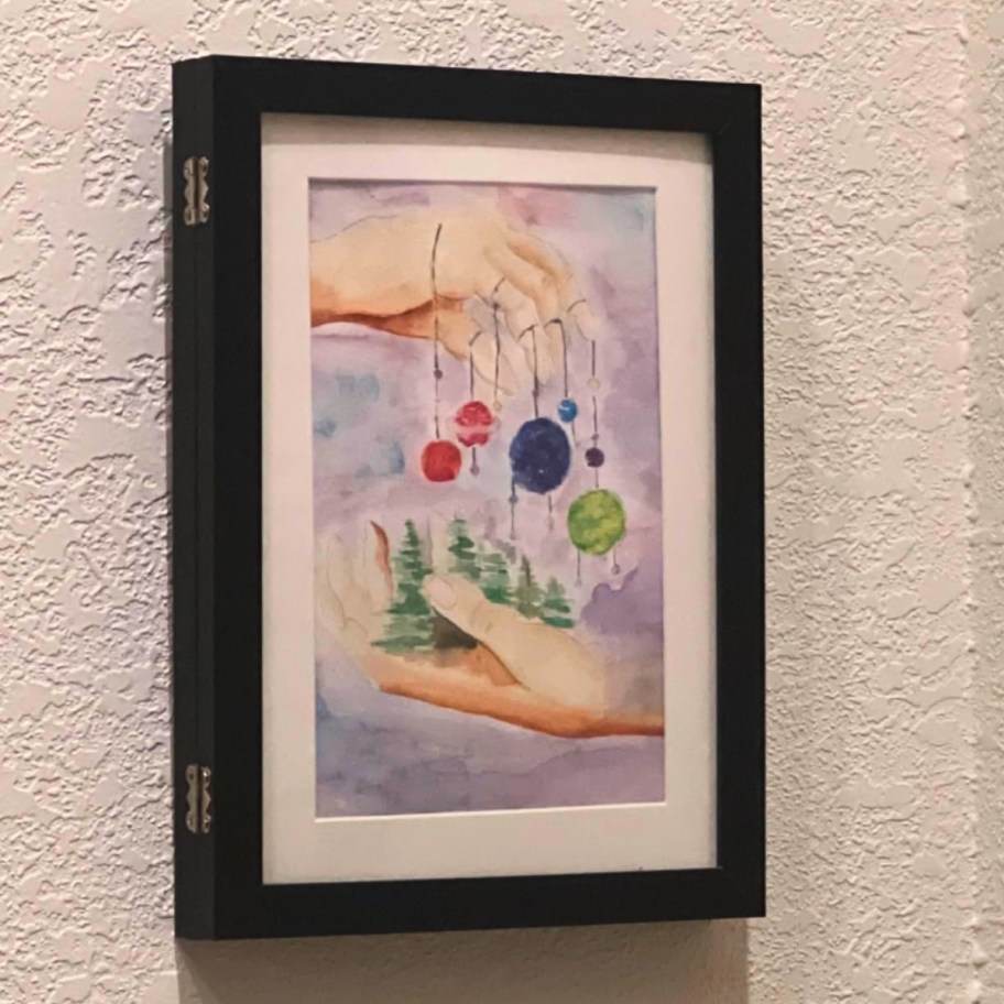 child's artwork displayed in picture frame on wall