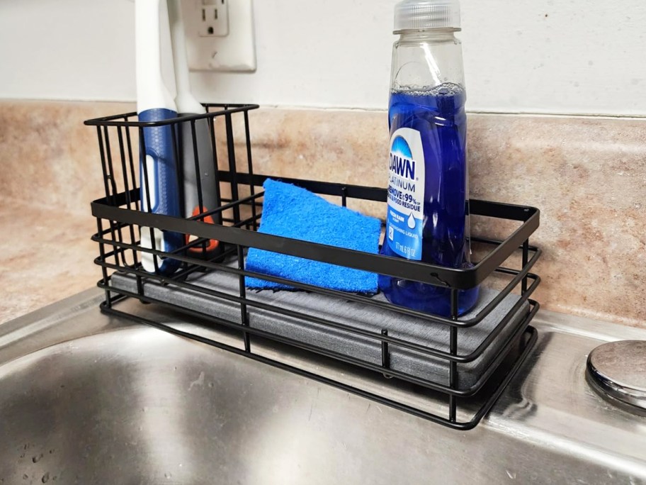 black sink caddy with sponge, soap, and brushes