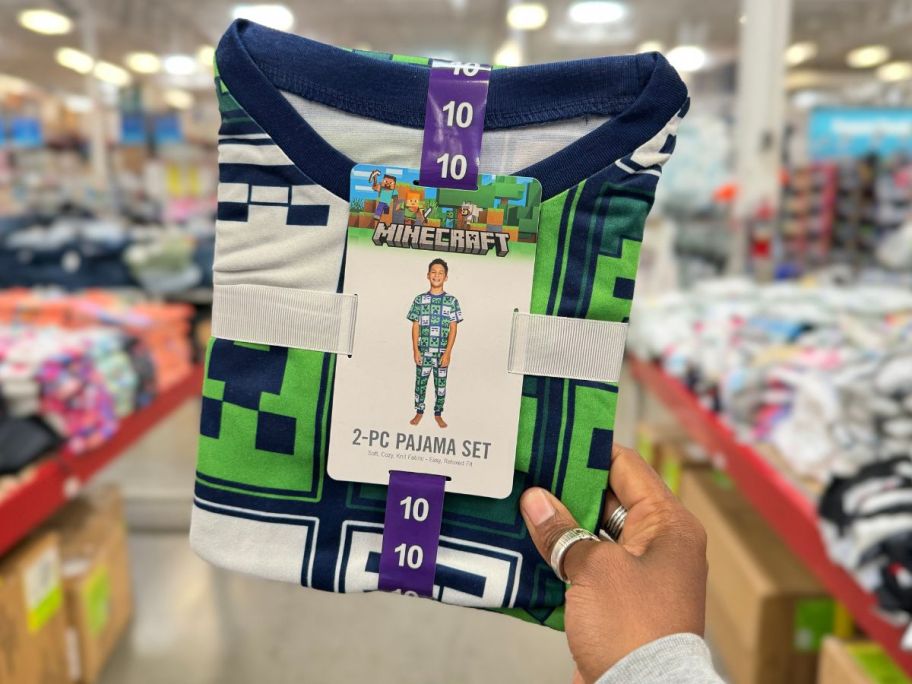 A hand holding a Minecraft 2-piece Pajama Set in Sam's Club 