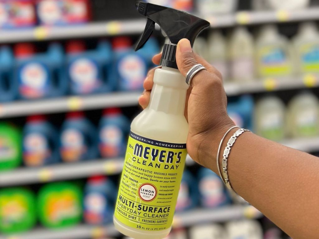 Hand holding up a bottle of Mrs Meyer's Lemon Verbena All Purpose Cleaning Spray