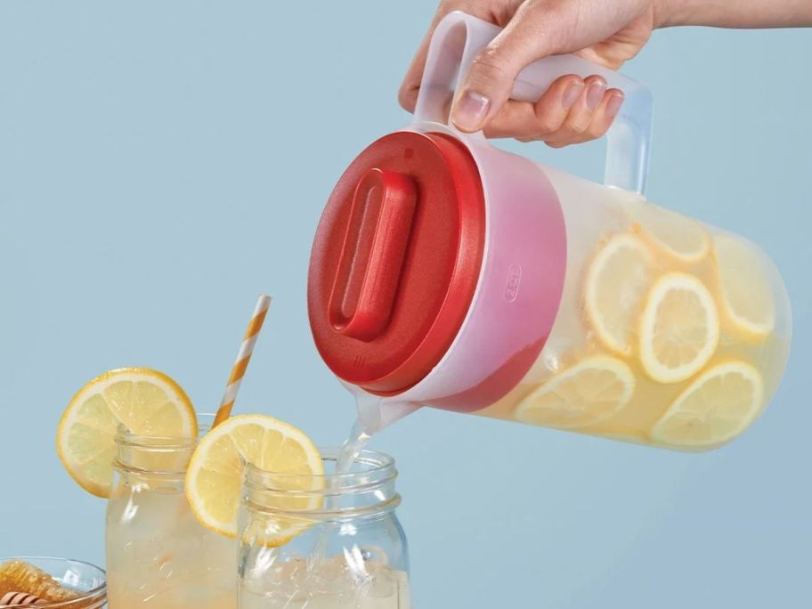 Hand pouring lemonade into mason jars with a rubbermaid 2-quart pitcher