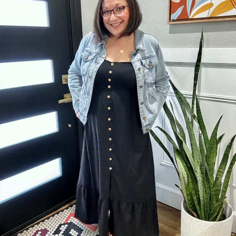 Lina waring a black women's sundress that has buttons down the front with a jean jacket