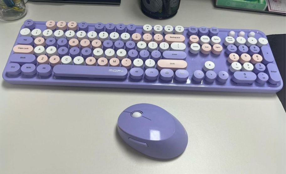 wireless keyboard and mouse bundle in purple on desk