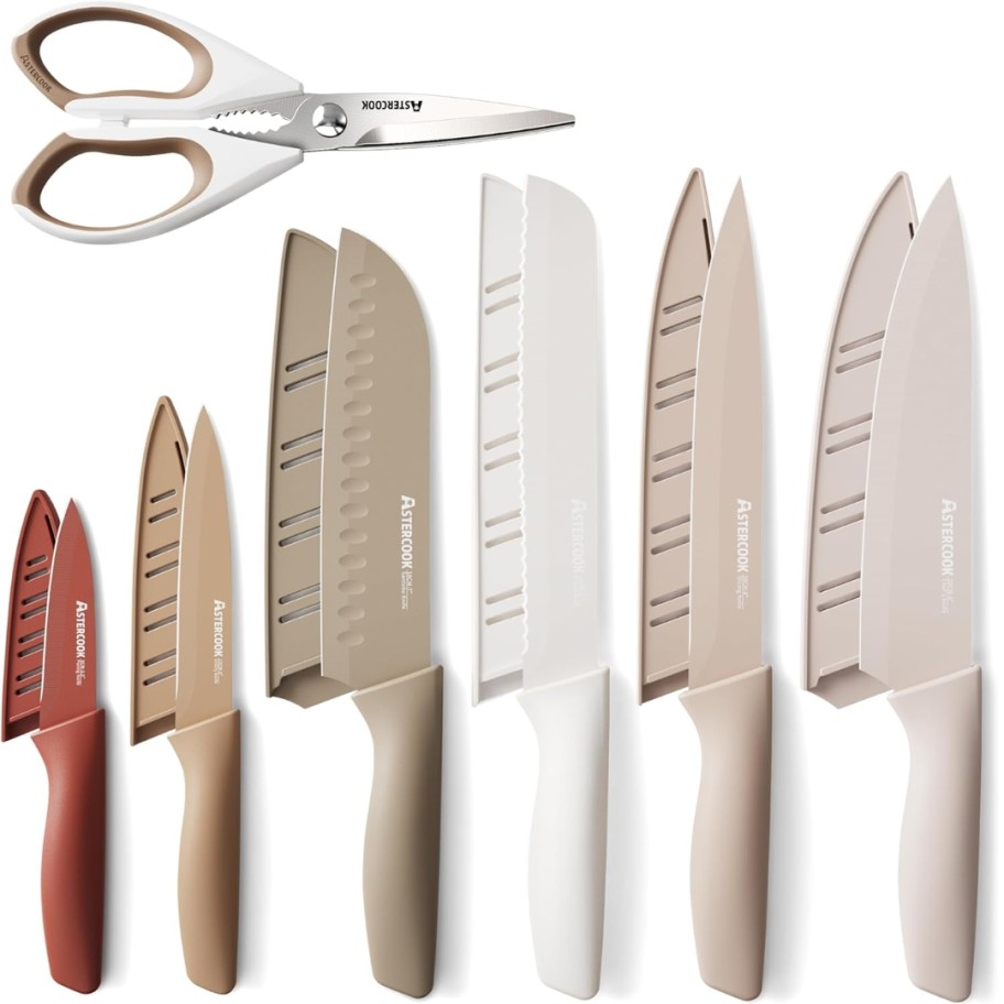a set of neutral color knifes with blade covers in various sizes and a pair of kitchen shears 