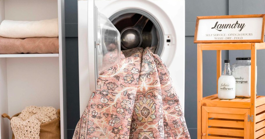 pink area rug with design hanging out of washing machine