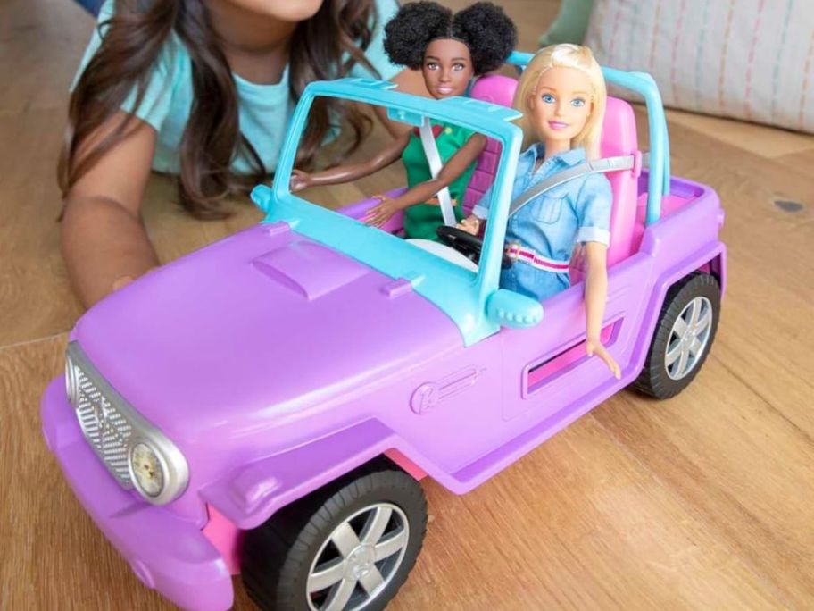 child playing with barbie jeep